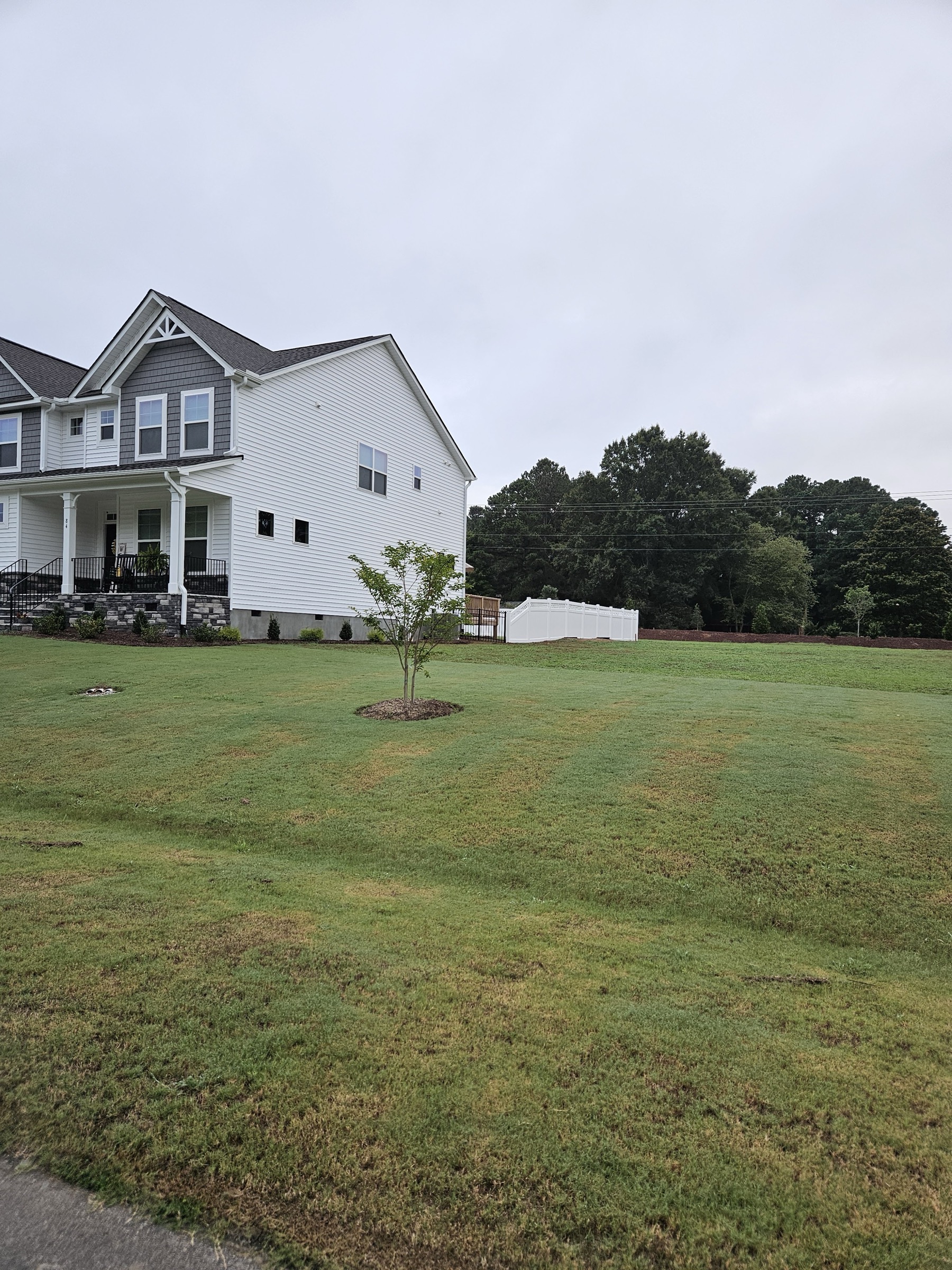 Clean white vinyl privacy fence along a rear property line.